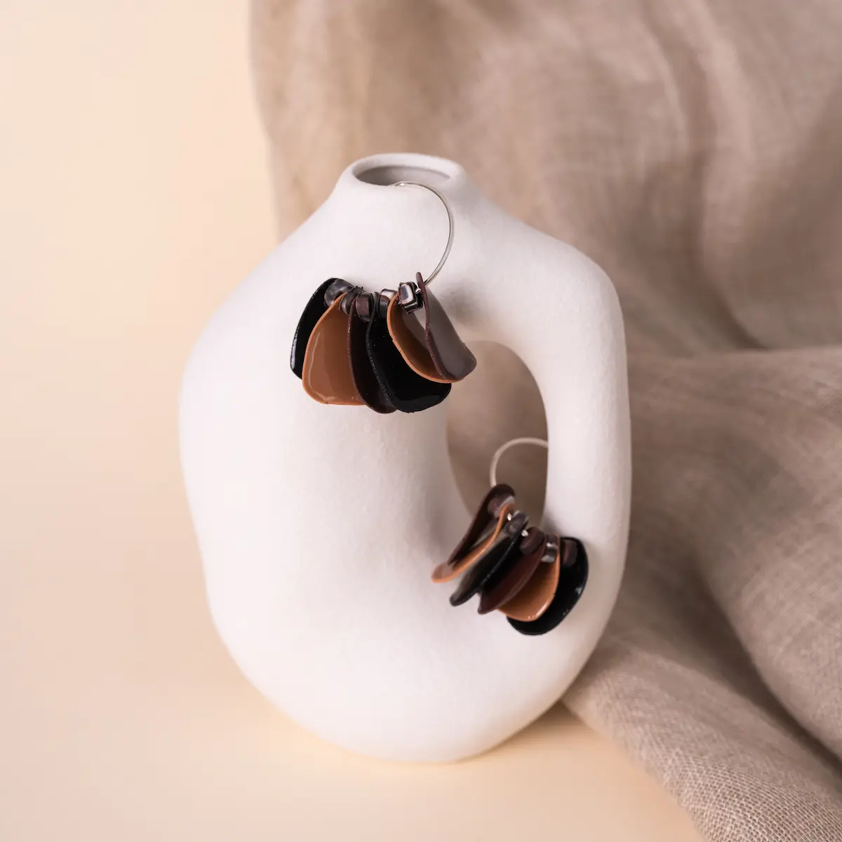 Pendientes artesanales Aire de leopardo, en plata de ley 925 y arcilla polimérica. Un aro de plata con pétalos en tonos negros y marrones. Ligeros y exclusivos.