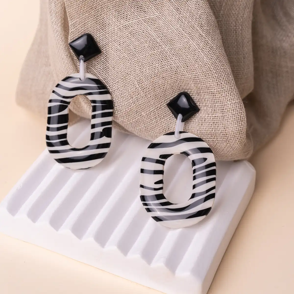 Pendientes artesanales Cebra Style 2.0, en plata de ley 925 y arcilla polimérica. Un rombo negro pegado al lóbulo con una pieza colgante estampada de cebra. Ligeros y exclusivos.