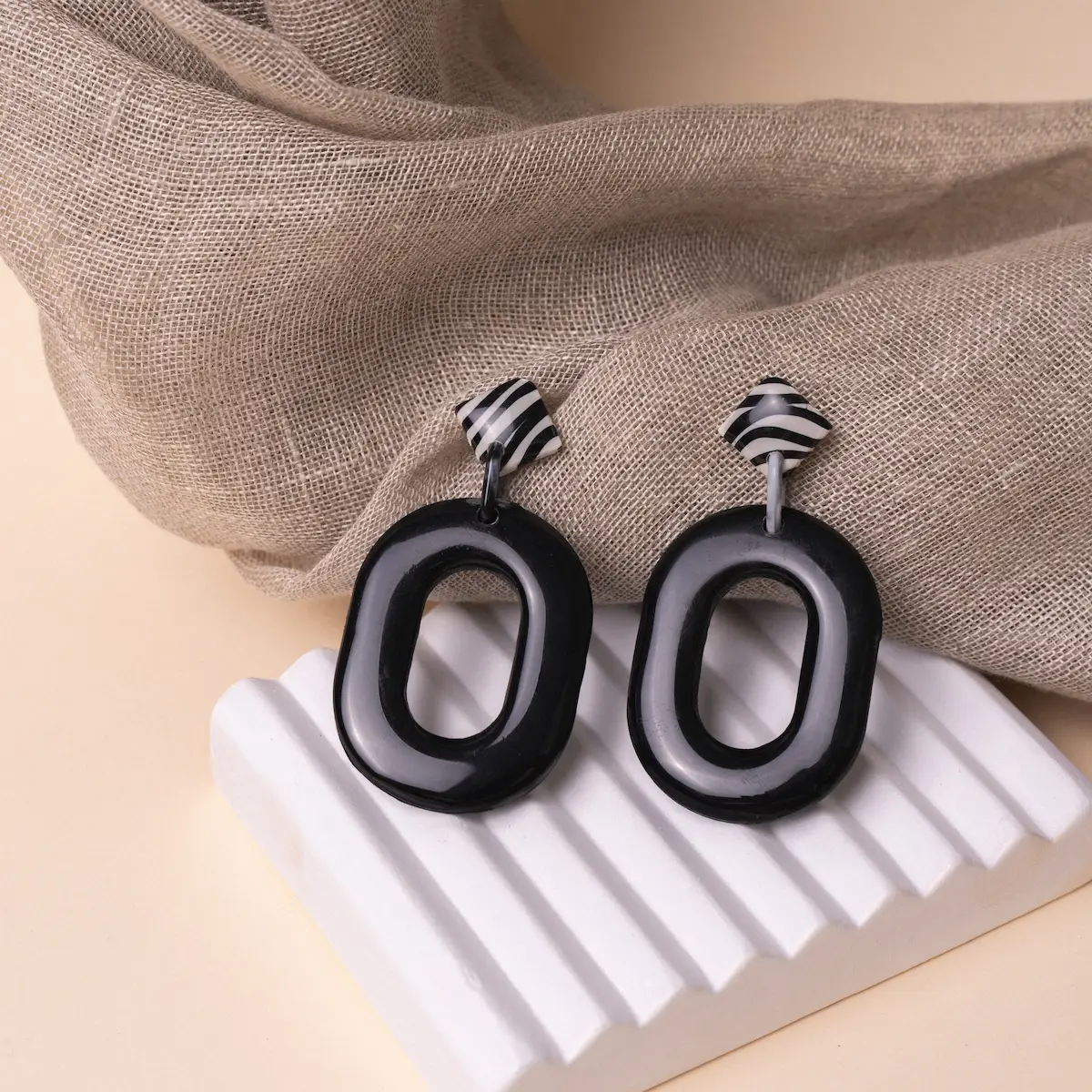 Pendientes artesanales Cebra Style, en plata de ley 925 y arcilla polimérica. Un rombo con estampado de cebra pegado al lóbulo con una pieza colgante en color negro. Ligeros y exclusivos.