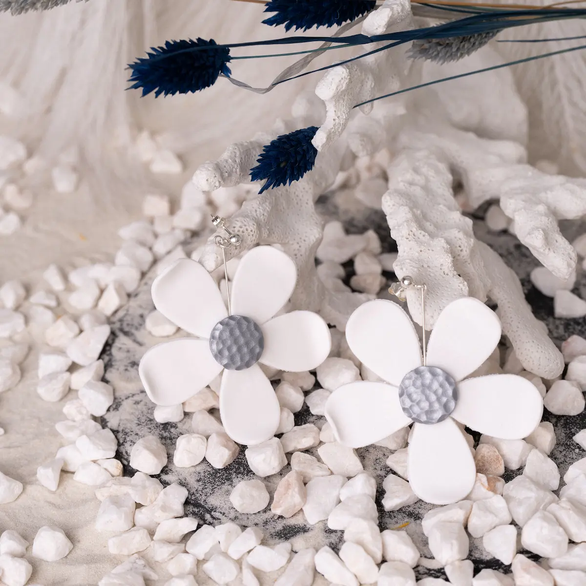 Pendientes artesanales Flor blanca pura de plata de ley 925 y arcilla polimérica, una pequeña esfera de plata pegada al lóbulo con una pieza colgante en forma de flor blanca grande con el centro en color plateado. Ligeros y exclusivos.