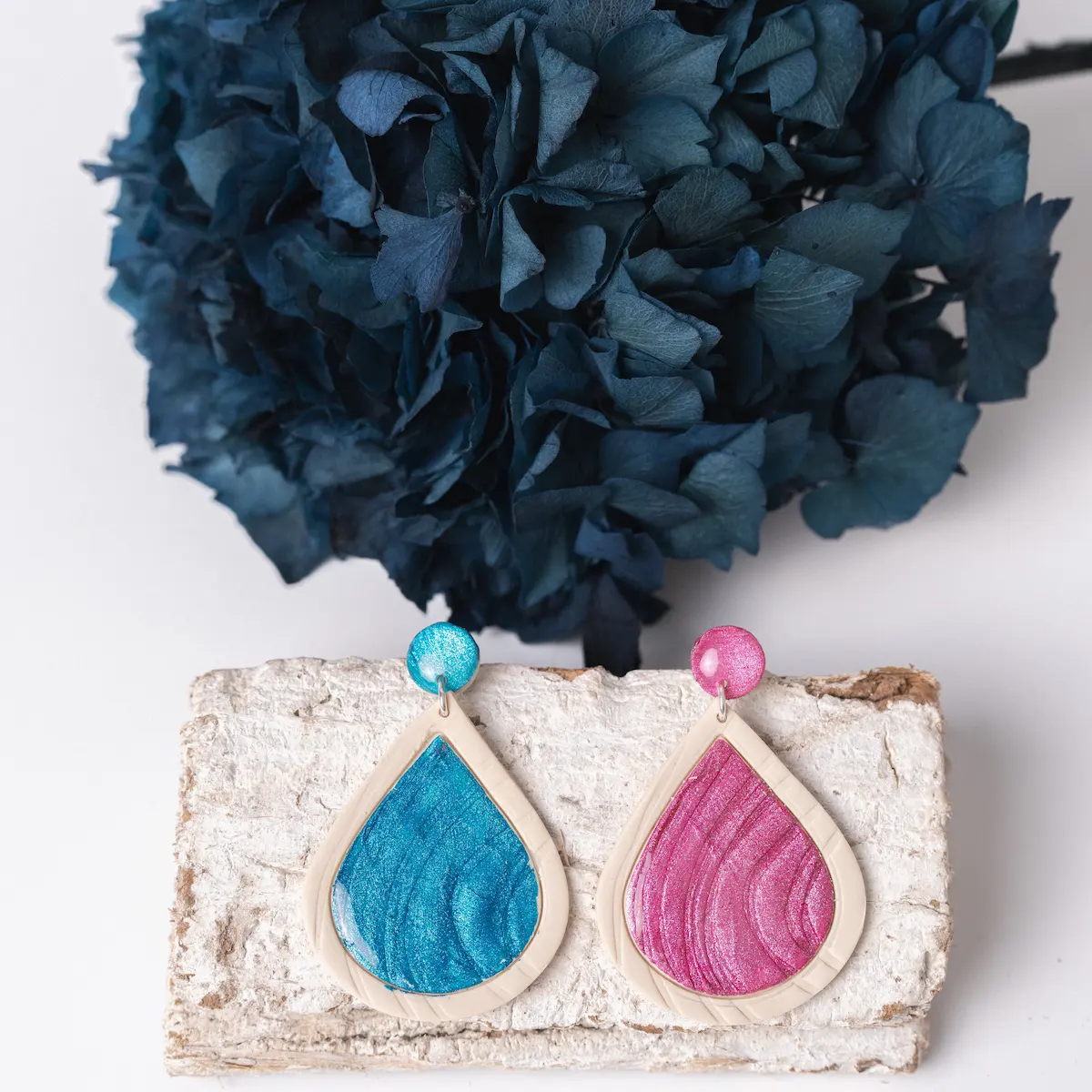 Pendientes de plata y arcilla polimérica y plata en color rosa o azul, un pequeño círculo pegado al lóbulo, con una pieza colgante en forma de gota. Decorados con pintura acrílica para lograr un brillo espectacular. Ligeros y exclusivos.