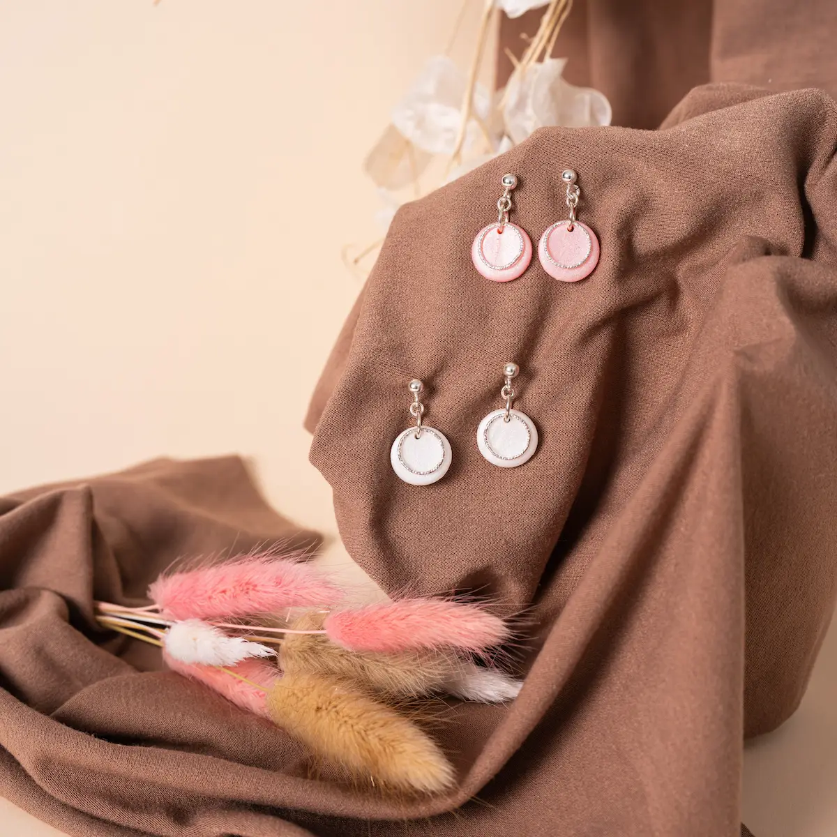 Pendiente de bolita de plata de ley 925 con arcilla un círculo de arcilla color nácar rosa o nácar blanco, puedes elegir el que más te guste y sobre él otro círculo de plata de ley 925 martilleada. Un diseño elegante y exclusivo.