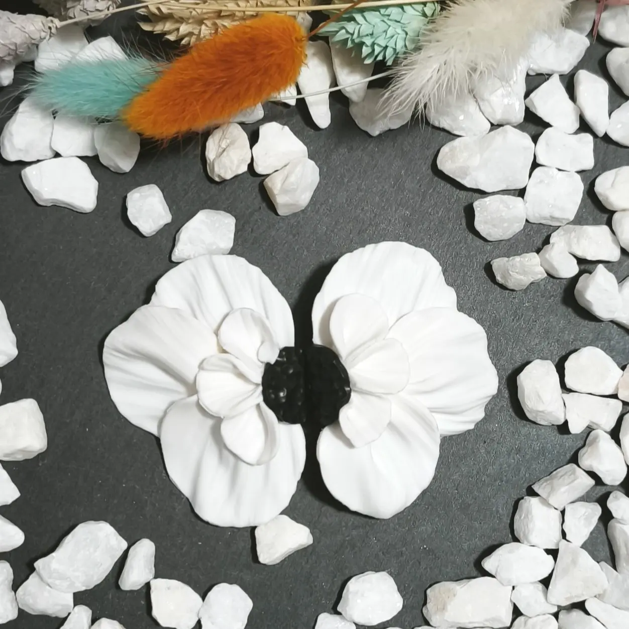 Pendientes artesanales de plata de ley 925 y arcilla polimérica en forma de media flor grande en color blanco con centro negro. Nuestro nuevo diseño de la colección aire floral. Un pendiente ideal para ocasiones especiales y eventos como bodas, comuniones y fiestas.