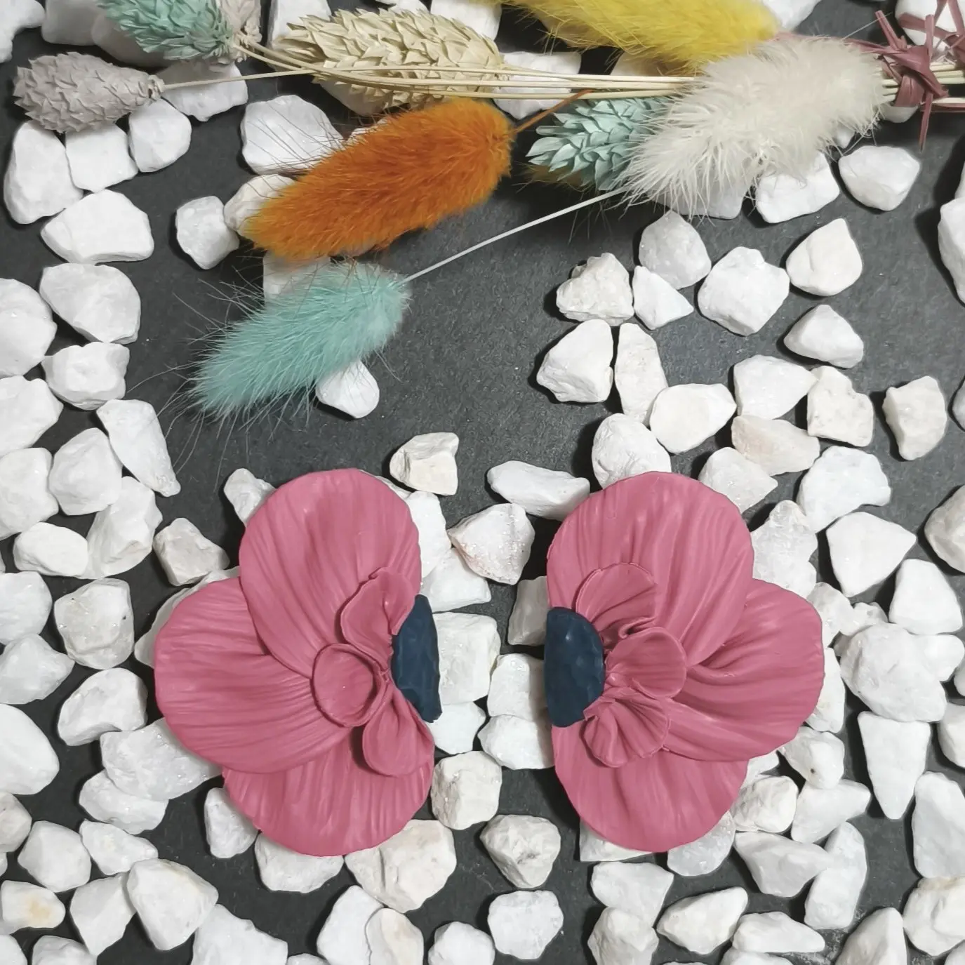 Pendientes artesanales de plata de ley 925 y arcilla polimérica en forma de media flor grande en color rosa con centro azul. Nuestro nuevo diseño de la colección aire floral. Un pendiente ideal para ocasiones especiales y eventos como bodas, comuniones y fiestas.