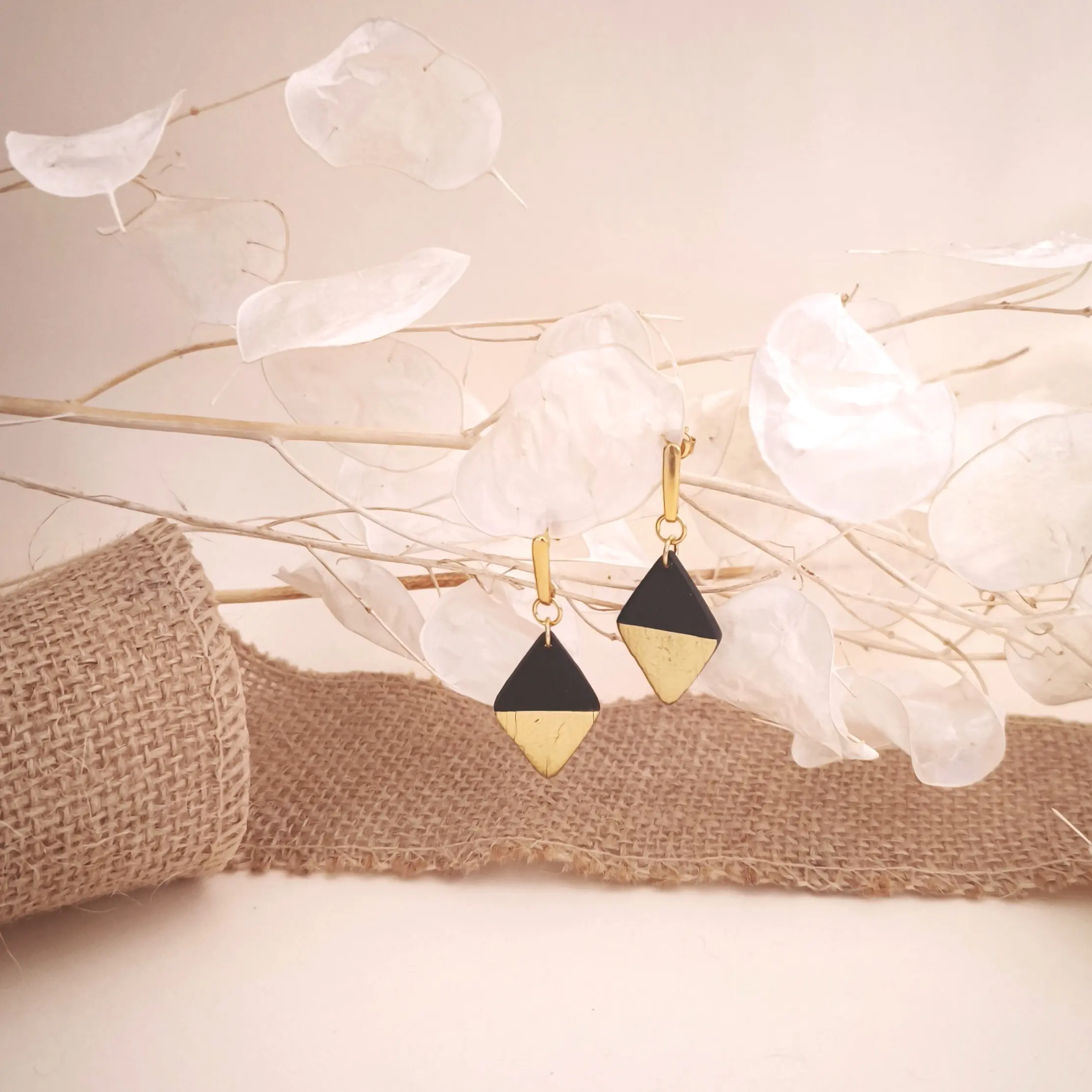 Pendientes de plata de ley 925 bañada en oro de 24 quilates, con una pieza colgante en forma de rombo de arcilla polimérica negra y detalles en pan de oro.