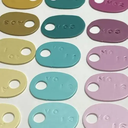 Muestrario de colores personalizados en arcilla polimérica con códigos de mezcla para el diseño de pendientes artesanales de Pabús Bijoux.