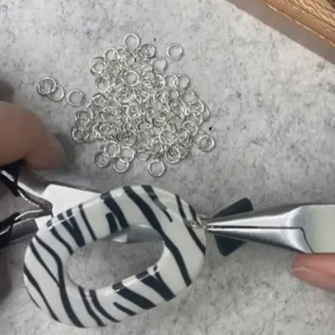 Proceso de montaje manual de pendientes de cebra con argollas de plata de ley 925 en el taller de joyería Pabús Bijoux, Bilbao.