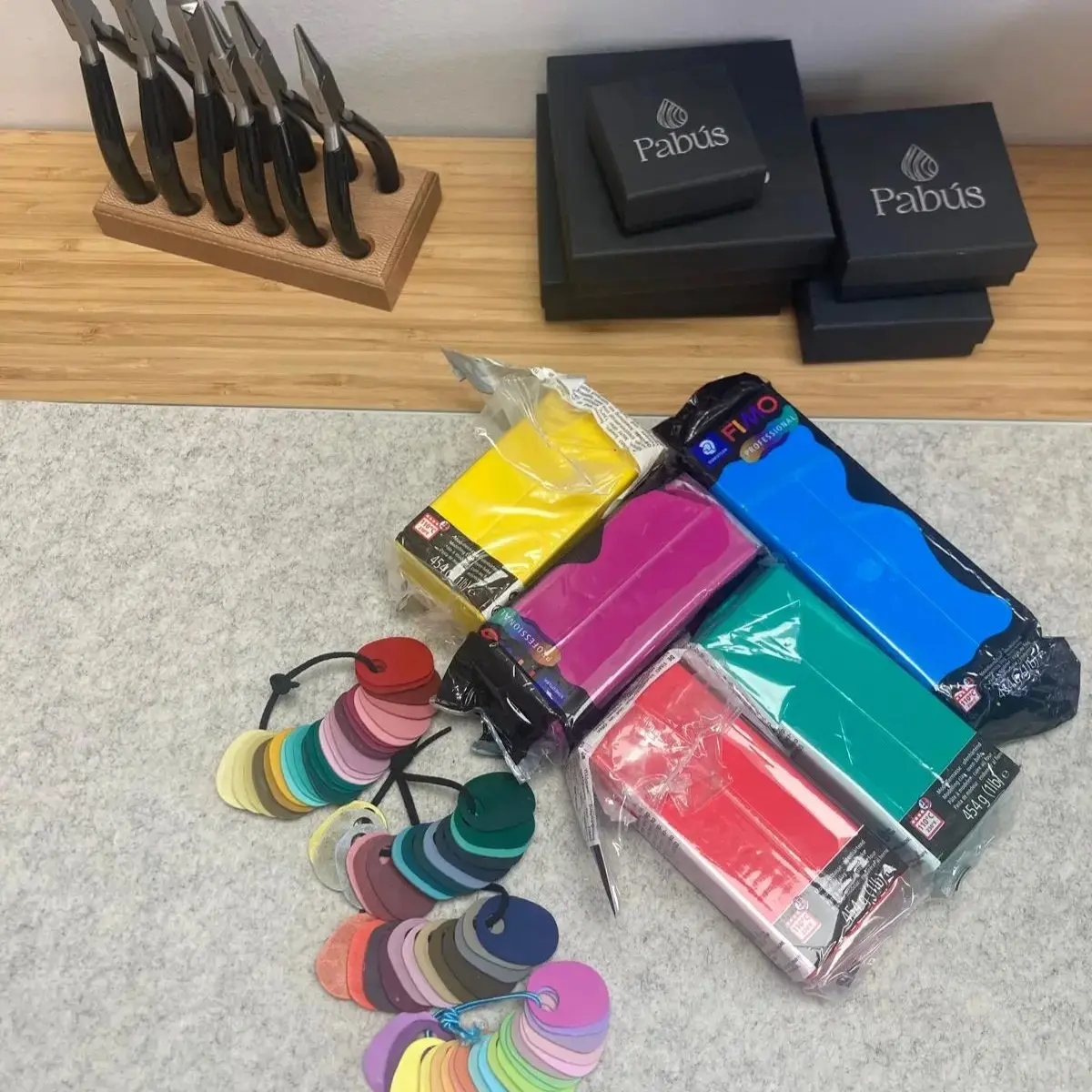 Primer plano de herramientas de joyería y paleta de colores en el taller de Pabús Bijoux, Bilbao.